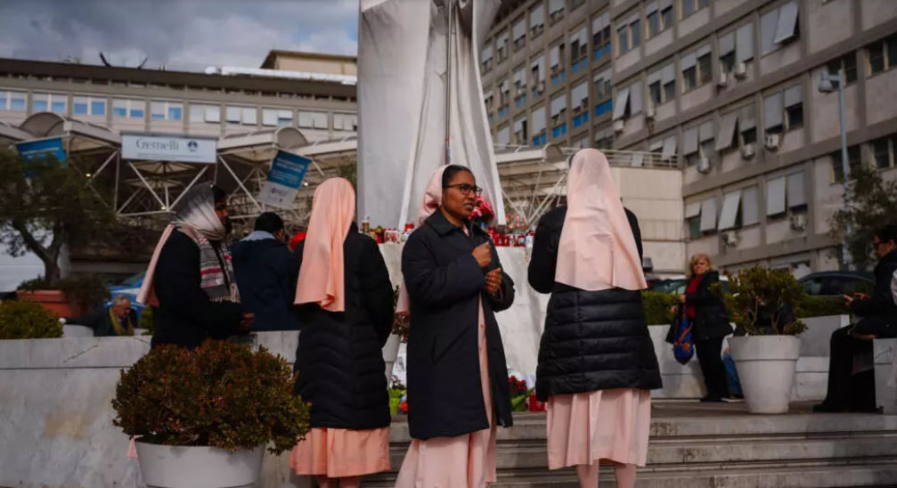 CIUDAD DEL VATICANO. Unas monjas rezan por el papa Francisco ante la estatua del pontífice Juan Pablo II en el exterior del hospital Gemelli de Roma afp