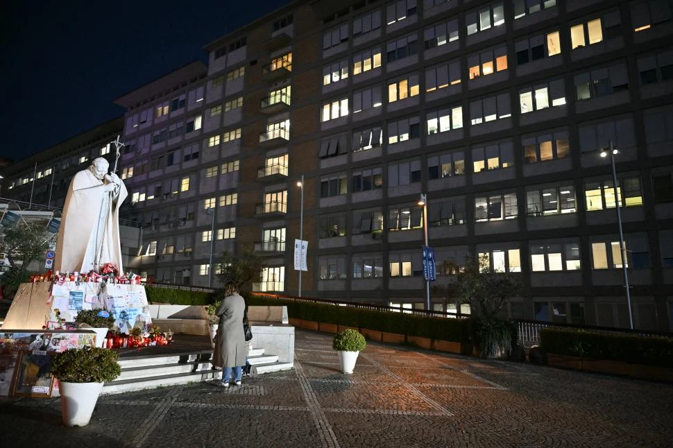 REZOS. Los fieles encienden velas frente al hospital donde está el Papa.