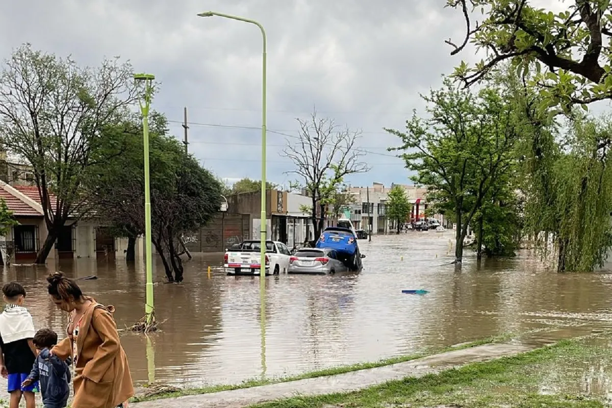 PREOCUPACIÓN. La esposa de Bellone y sus hijos se alejan de las calles, que quedaron colapsadas de autos apilados por el agua.