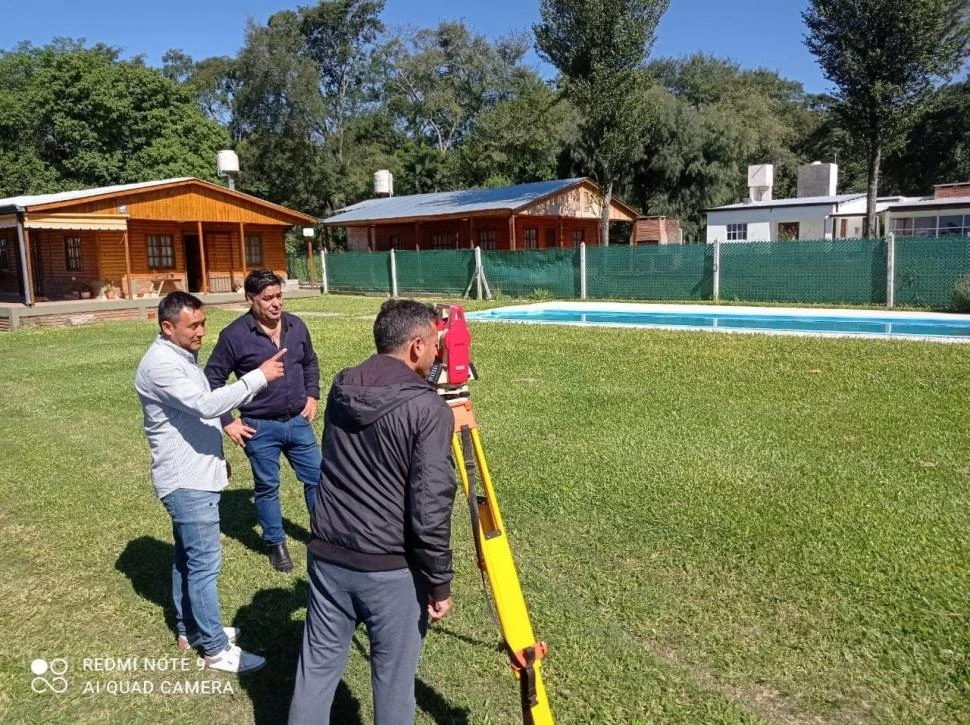 VIDEO DE VECINOS. El comisionado Dante Delgado y Rafael Trujillo observan a Maximiliano Barreiro hacer mediciones para una futura mensura.