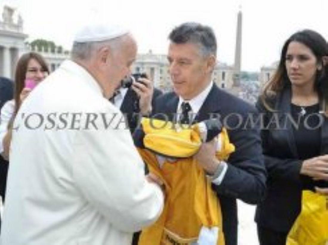 EL OBSEQUIO. Paoletti le entrega el traje antiflama a Bergoglio.