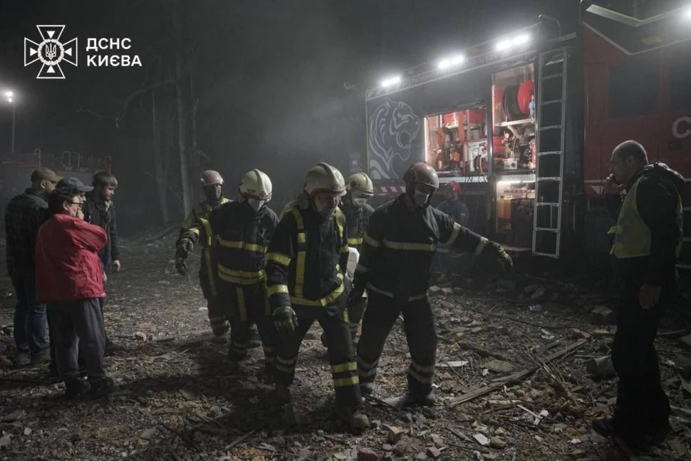 SECUELAS. Los equipos de empergencias y rescatistas ucranianos retira los cuerpos de las víctimas del ataque ruso con misiles en un barrio de Kiev,