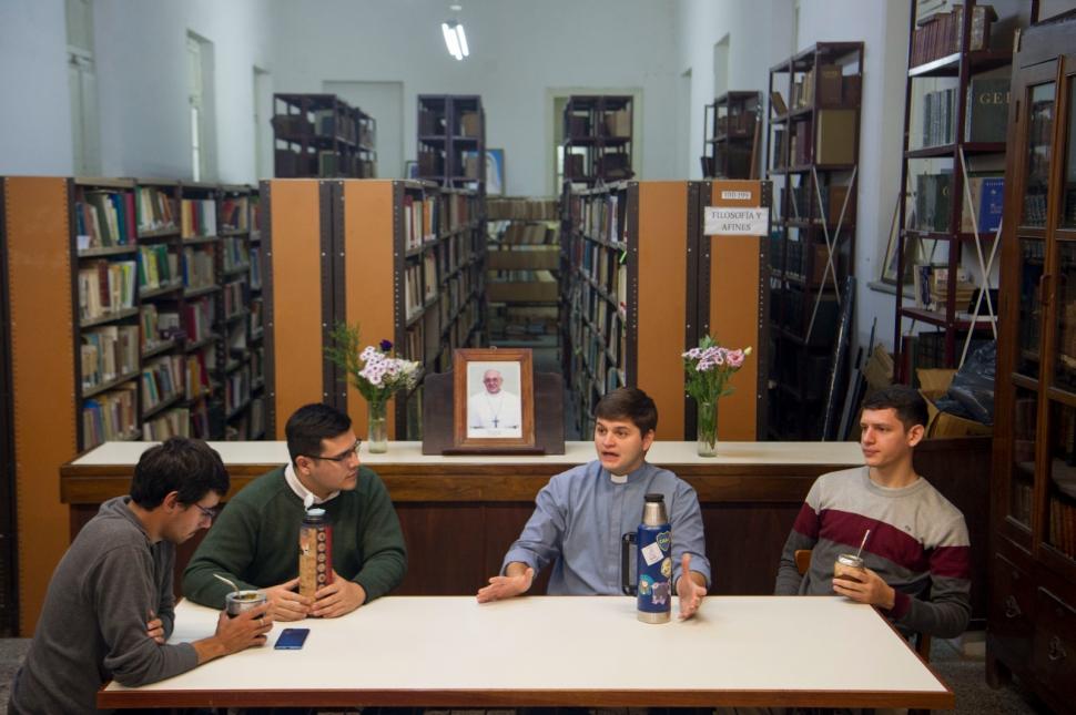 REFLEXIÓN. Los jóvenes comparten una charla profunda en la biblioteca del Seminario Mayor, rodeados de libros y con mate en mano, discutiendo sobre su llamado y la influencia del Papa Francisco en su vocación.