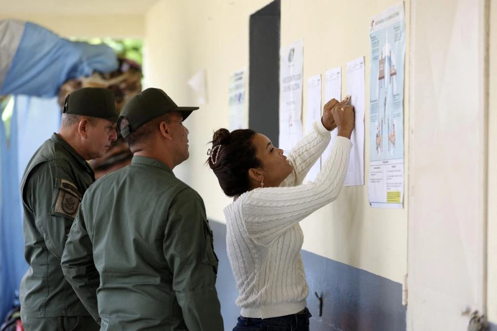 CHEQUEANDO EL PADRÓN. Las estaciones de votación estuvieron casi vacías y fuertemente custodiadas, por lo que el trámite de sufragar fue rápido. 