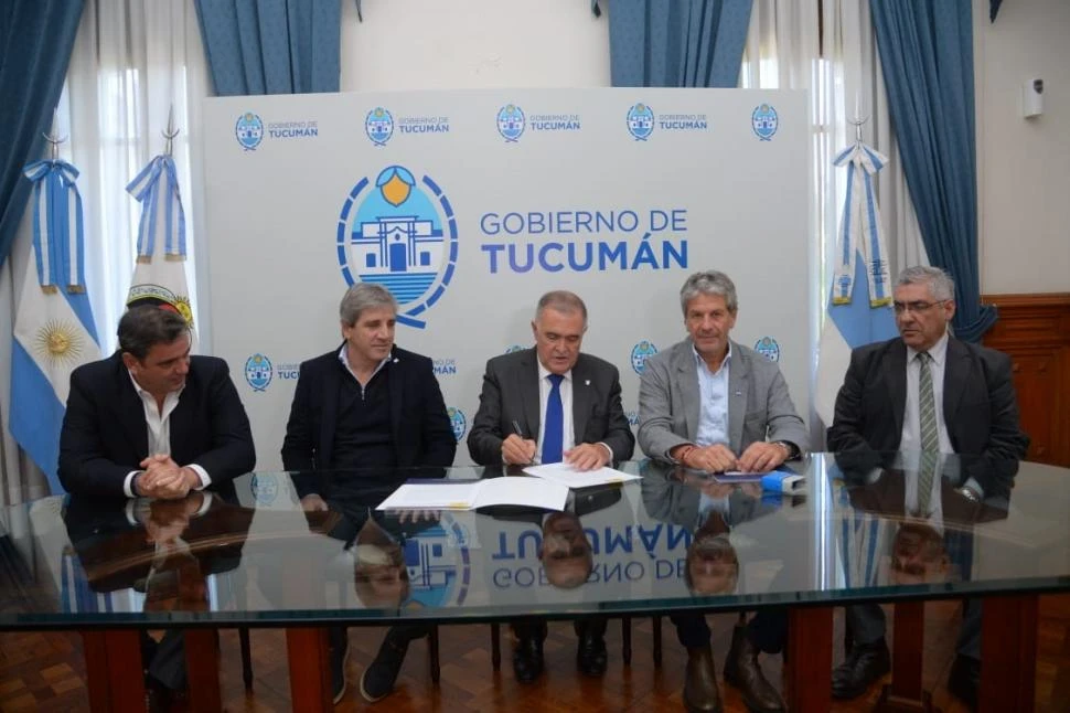 EN CASA DE GOBIERNO. El gobernador Osvaldo Jaldo firma el acuerdo con la Nación, ante la atenta mirada de Catalán, Caputo, Pazo y Abad. 