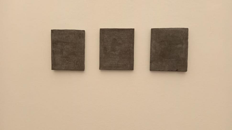 EN MOLDES DE CEMENTO. Escrituras e imágenes están superpuestas.