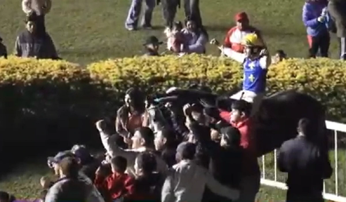 FESTEJO. El jinete José Alfredo Vizcarra, que le brindó una acertada conducción a Cima Himalaya, celebra la victoria junto a los seguidores del stud “Monterrico”.