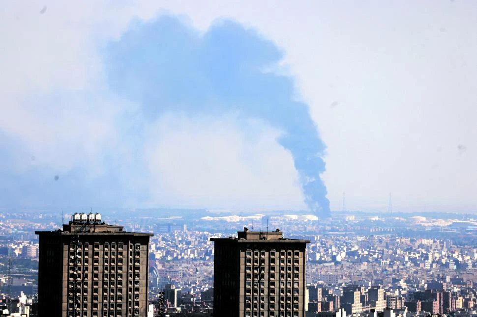 BAJO FUEGO. El humo se eleva desde una refinería de petróleo, luego de un ataque israelí sobre Teherán.