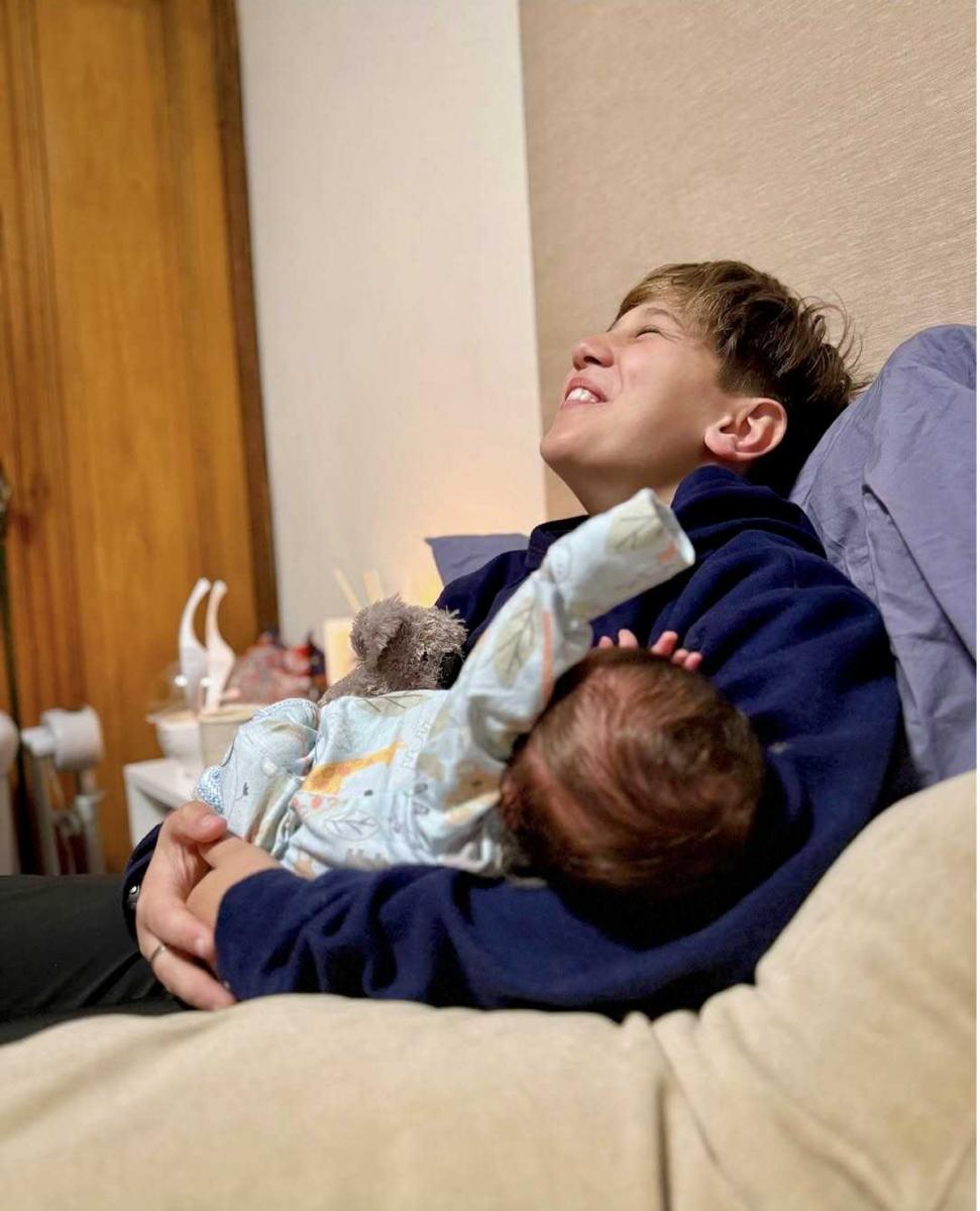 Momo cargando a su hermano recién nacido.