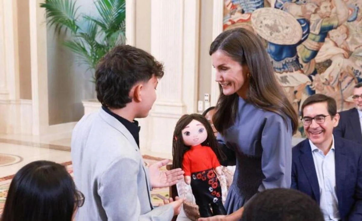 UN REGALO ESPECIAL. El becado colombiano Sebastián Carreño entrega a la Reina una muñeca de trapo, que replica su imagen, hecha a mano por su madre que tiene un pequeño negocio de artesanía  JOSÉ JIMÉNEZ/CASA DEL REY