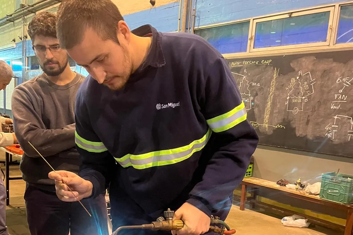 EN EL TALLER. Patiño suelda mientras Enrico observa la tarea durante el curso de instaladores de aires de la Facet. / CORTESÍA SANTIAGO PATIÑO