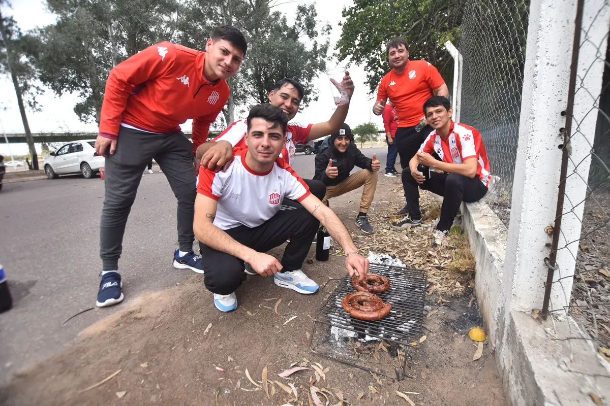 FELICES. Los hinchas posan junto a la parrilla a minutos para el inicio del partido.