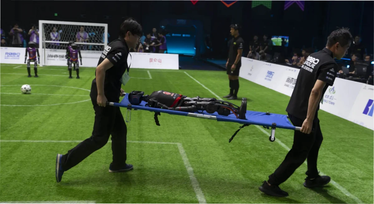 Trabajadores manejan un robot T1 de Booster Robotics durante la competencia inaugural de fútbol de robots RoBoLeague, celebrada en Pekín el sábado 28 de junio de 2025. (Foto AP/Ng Han Guan)