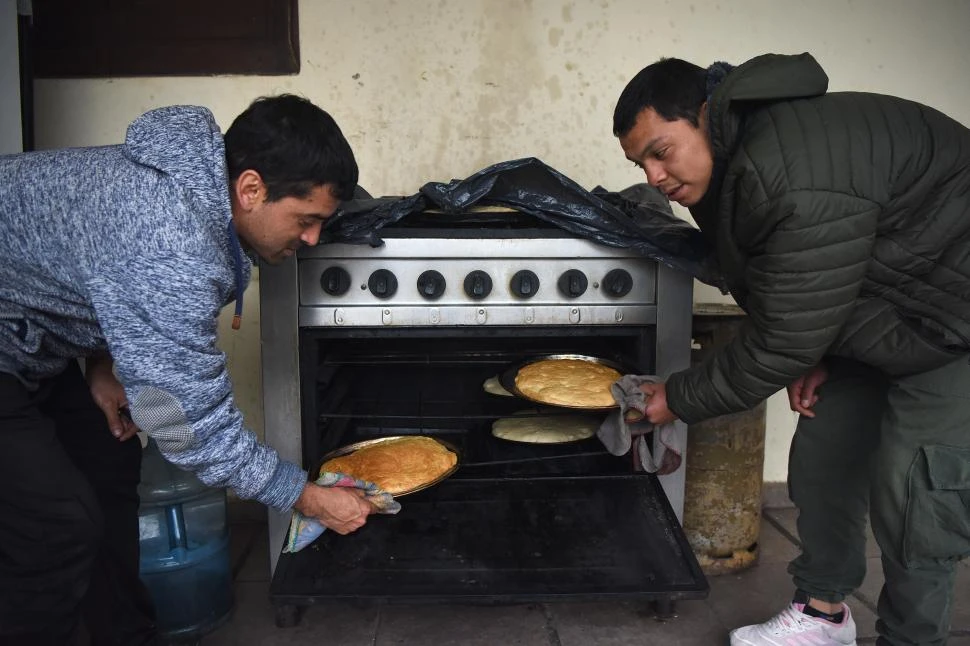 COCINEROS. Ramiro y su compañero sacan dos panes del horno. 