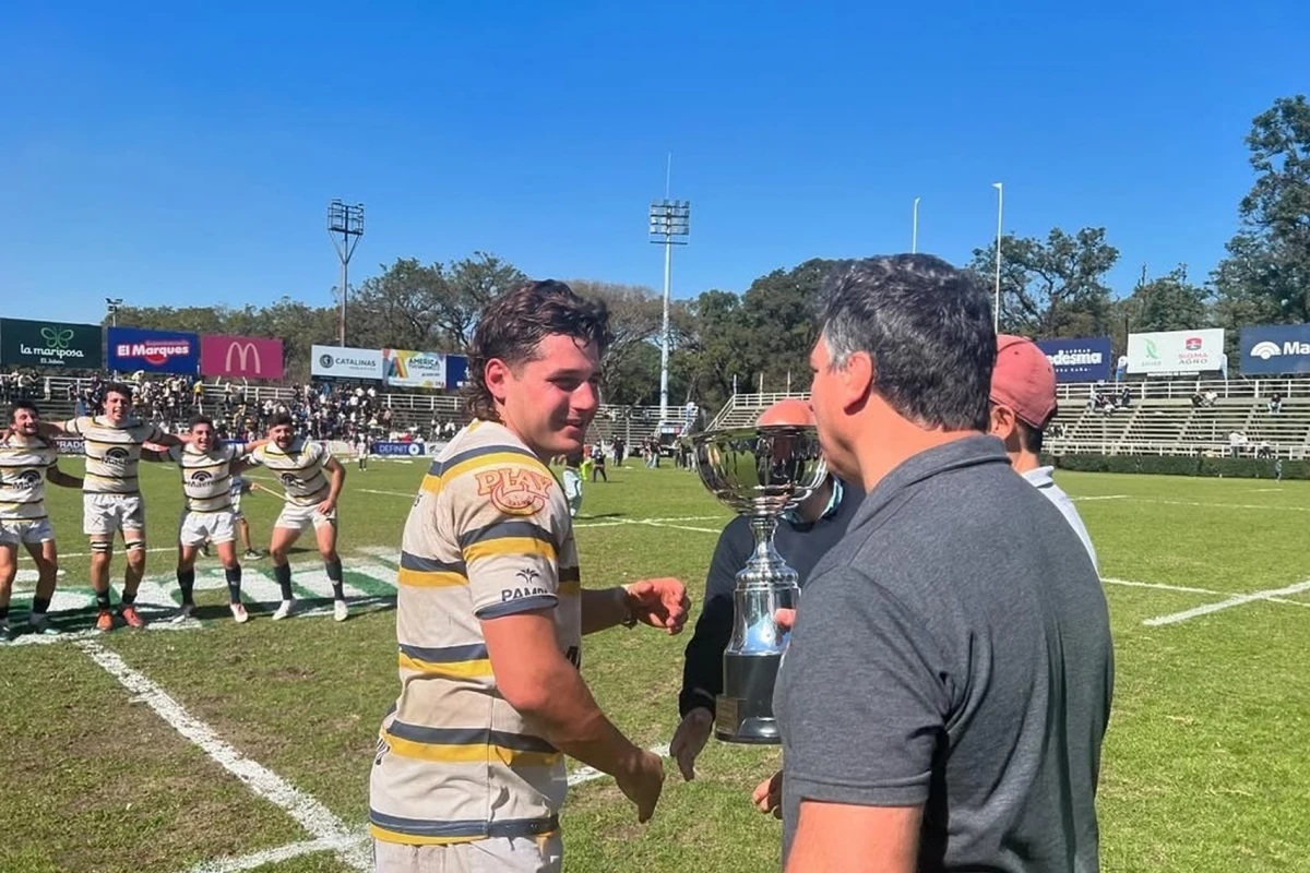 MOMENTO CÚLMINE. Benjamín Heredia, capitán de Lawn Tennis, recibe la copa de Intermedia de manos de directivos de la Unión de Rugby de Tucumán.
