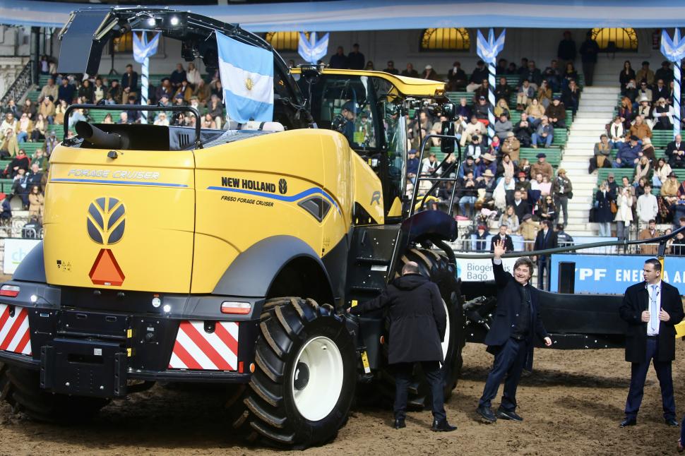 EN LA PISTA CENTRAL. Milei saluda luego de mirar las maquinarias.