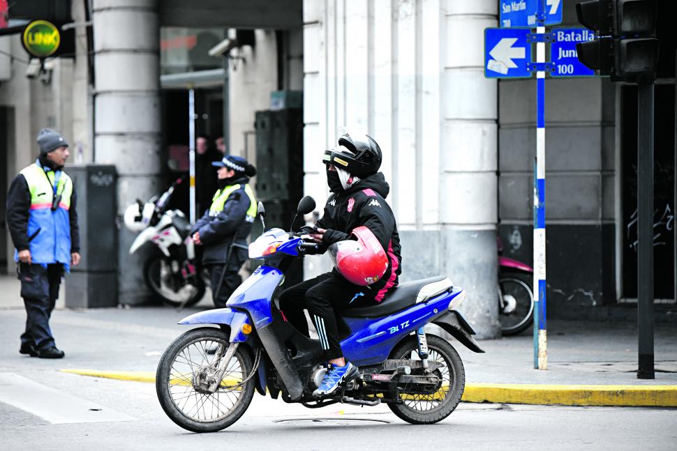 HABLANDO POR CELULAR. Pasa cerca de un policía.