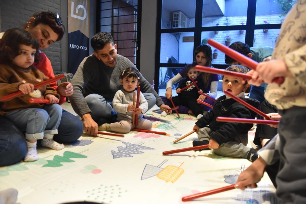 CON PALITOS. Los niños practican ritmos con sus padres y la tallerista.
