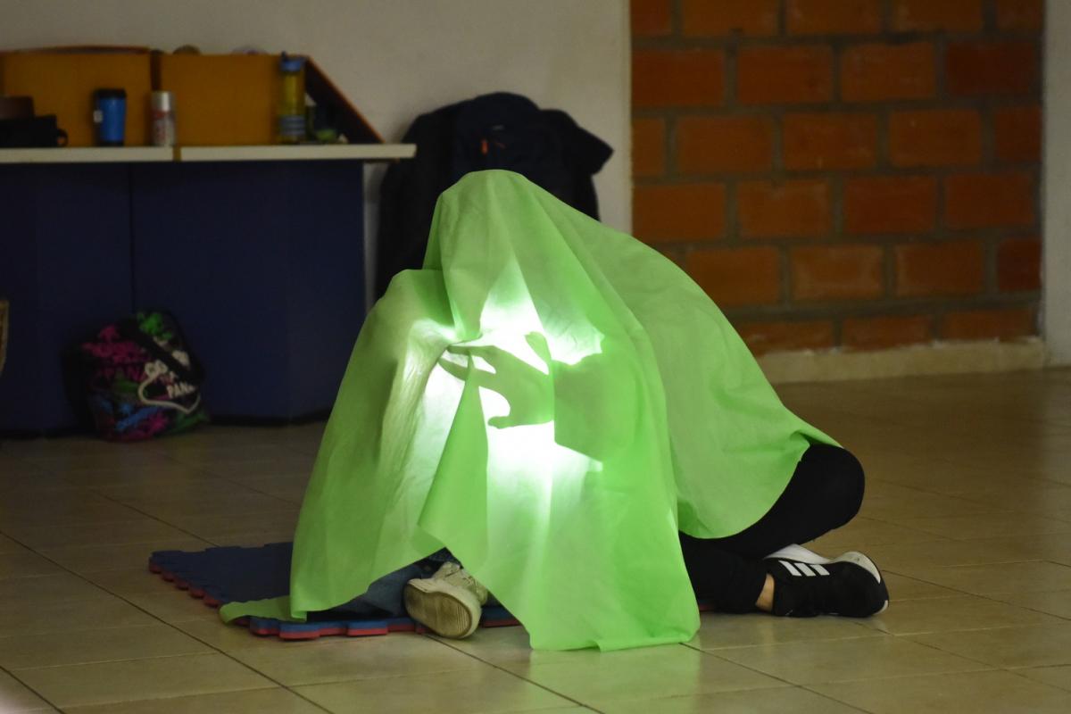 EL CIERRE DE LA CLASE. La profesora, Lurdes, y su alumna cantan y hacen sombras con una linterna.