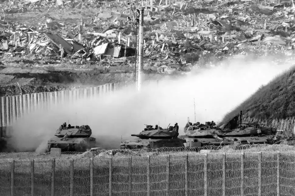 BLINDADOS. Los tanques israelíes bordean la frontera con la Franja de Gaza, donde los edificios destruidos testimonian los meses de bombardeos.