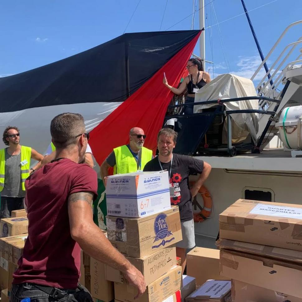 CARGAMENTO. Voluntarios suben las cajas con alimentos a la cubierta.