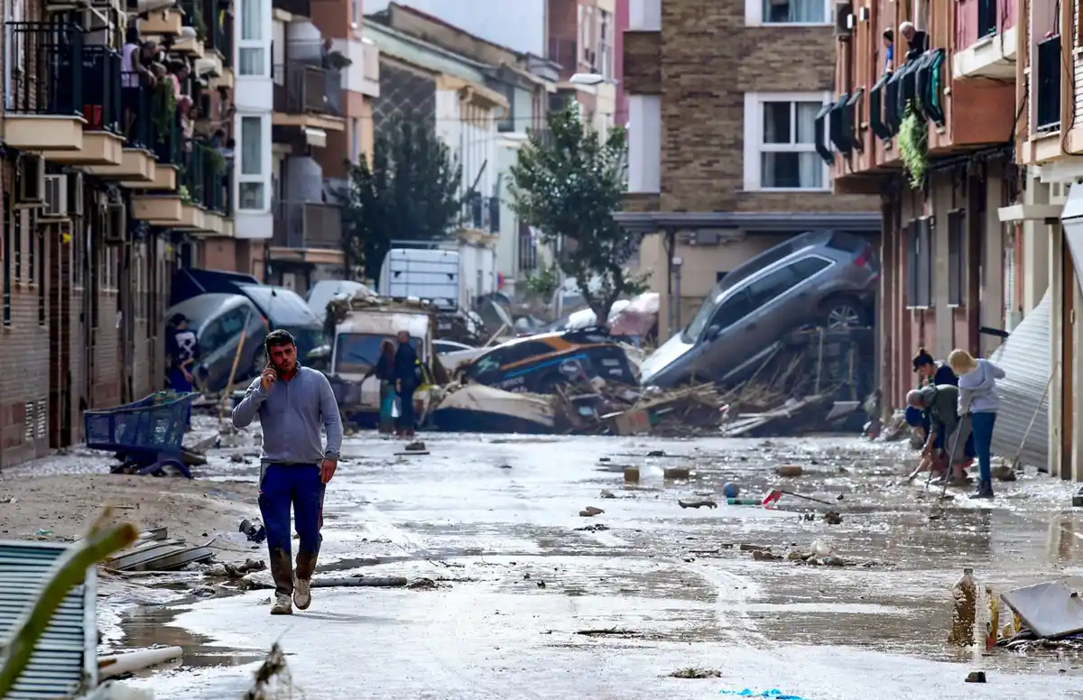 Residentes junto a coches amontonados en una calle cubierta de barro tras las inundaciones en Picanya, cerca de Valencia, el 30 de octubre de 2024. ( AFP)