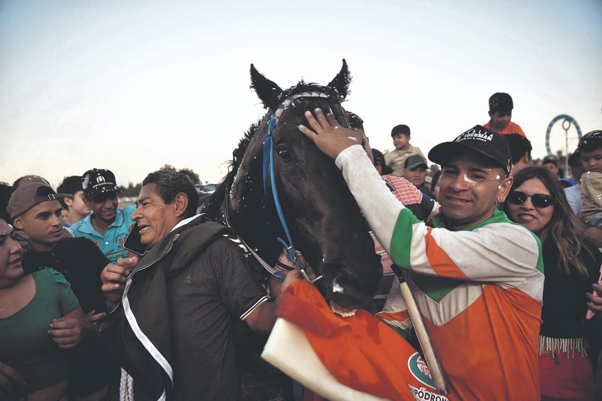 EMOCIONADOS. El peón y el jockey agradecen la entrega que mostró el zaino. 