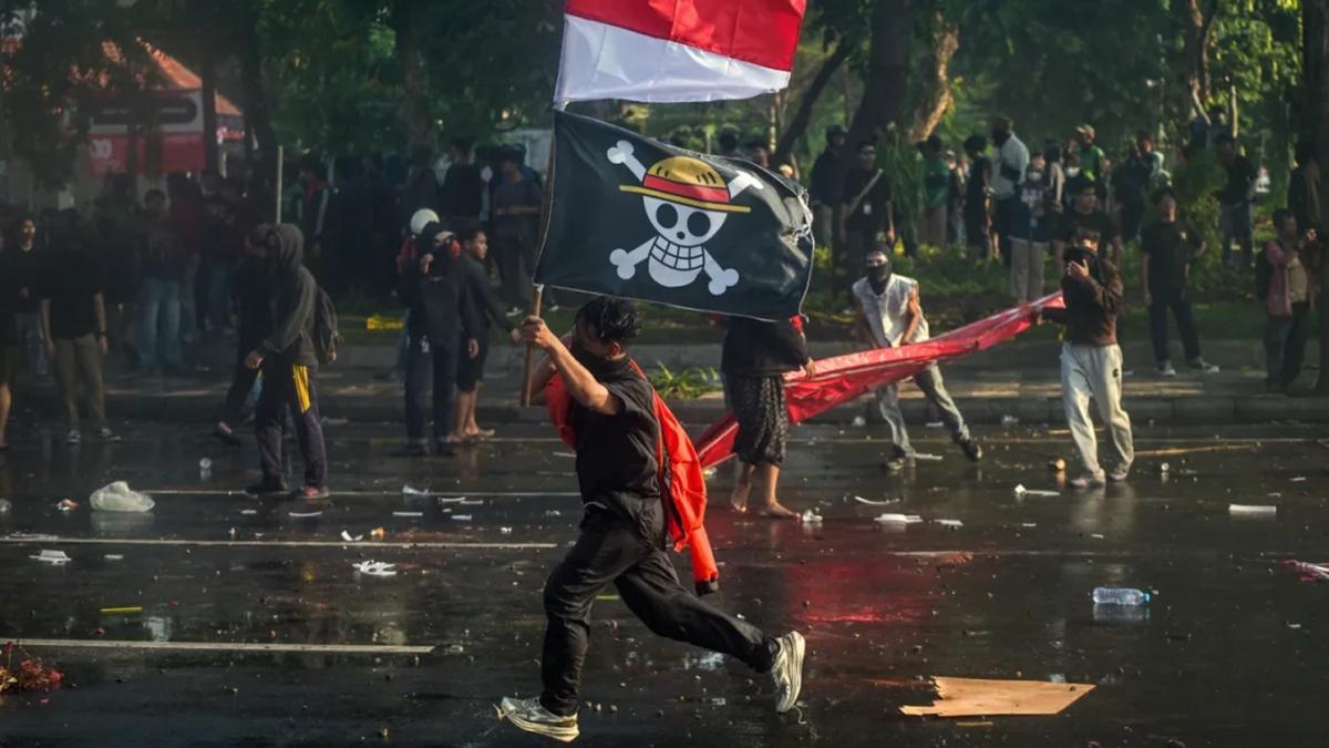 MÁS EJEMPLOS. Un manifestante lleva la bandera nacional de Indonesia y una bandera pirata del anime japonés One Piece durante una protesta frente a la residencia del gobernador en Surabaya, el 29 de agosto. / GETTY IMAGES