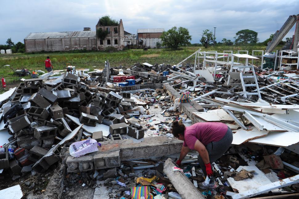 SOLIDARIDAD. Una vecina recoge mercadería que pudo recuperarse.