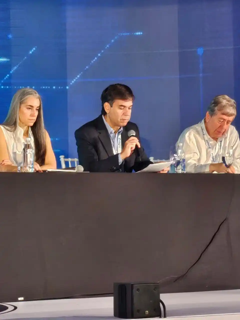 COROLARIO. Daniel Dessein lee las conclusiones, acompañado por Gabriela Vivanco y Roberto Rock.