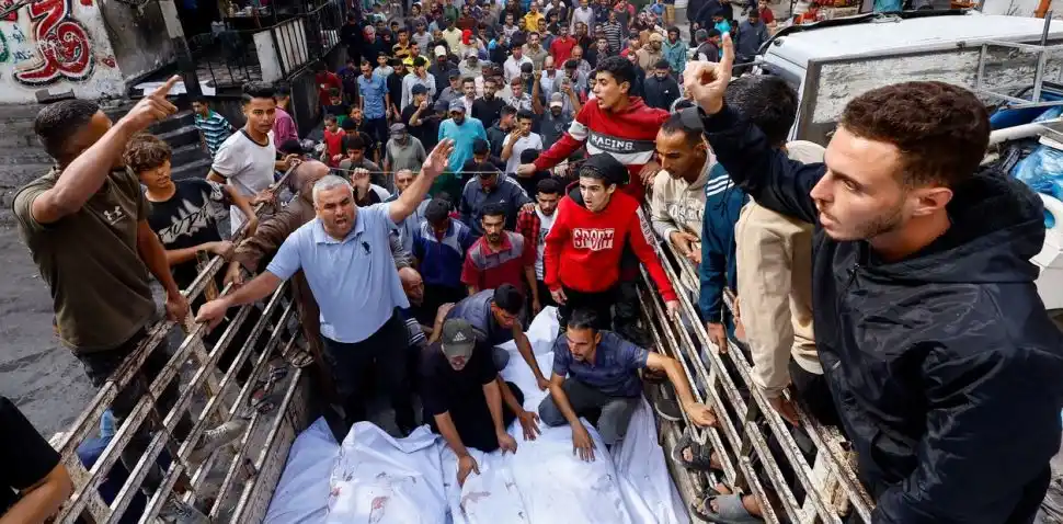 DOLOR. Palestinos cargan los cuerpos hallados entre las ruinas de Gaza.