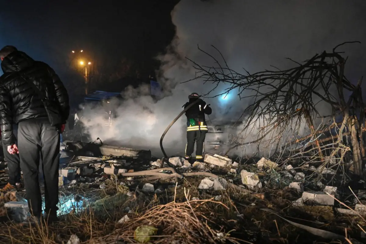FUEGO. Bomberos extinguen un incendio en el sitio donde golpeó una bomba arrojada desde un dron ruso, en Kharkiv, al noroeste de Ucrania.  afp