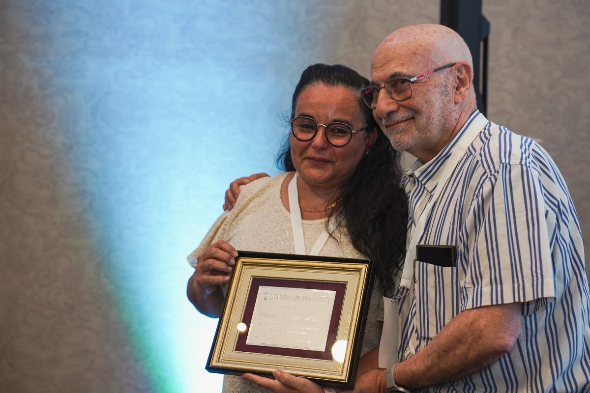 El doctor Carlos Pesa entrega reconocimiento a Claudia Molina. 