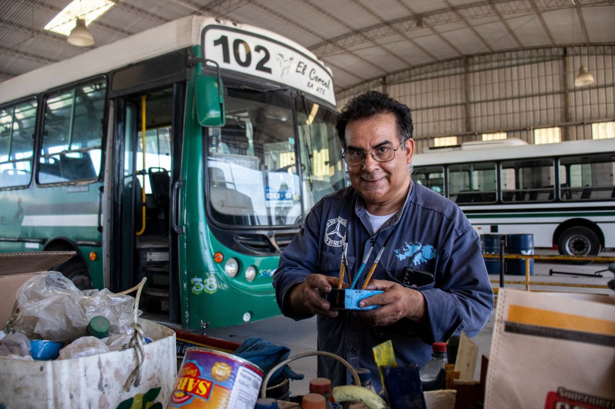 CON SUS HERRAMIENTAS. José Pedro Ríos sostiene los pinceles en el taller donde pinta los colectivos con estilo fileteado.