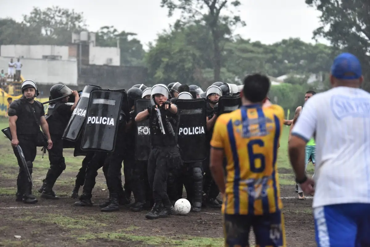 CAOS. La Policía custodia a los árbitros; los jugadores y el cuerpo técnico de San Pablo se acercan a protestar.
