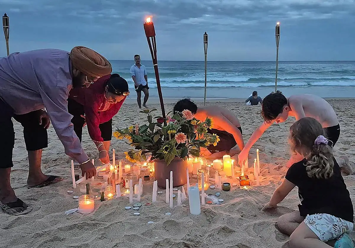 HOMENAJE. Con velas y lámparas, en Playa Manly de Sídney, hubo un día nacional de para honrar a las víctimas del tiroteo del 14 de diciembre.
