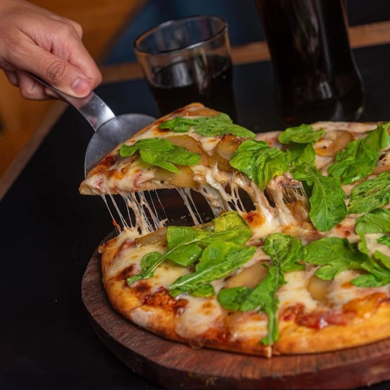 LA PIZZADA: DE AUTOR. Rúcula fresca, peras, roquefort y nueces crocantes sobre base de masa esponjosa. Reversión de las pizzas típicas del centro.