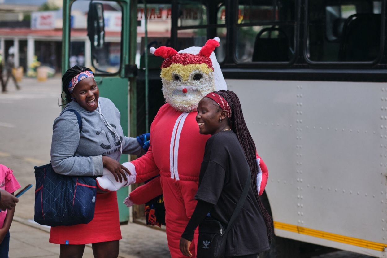 ZIMBABWE. Una “Señora Claus” recibe a los pasajeros en una parada de ómnibus de la ciudad de Bulawayo.