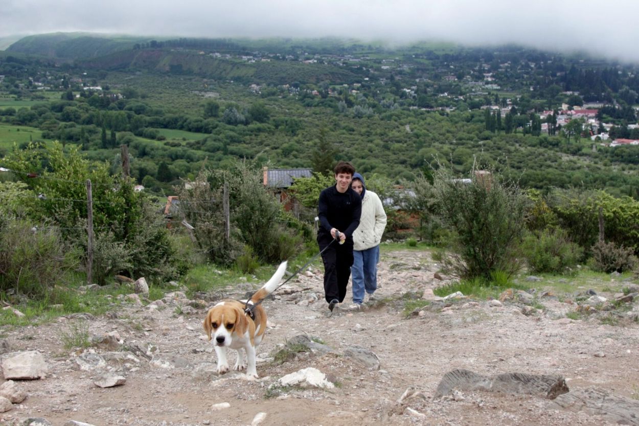 CON LA MASCOTA. Una pareja lleva de paseo al perro por el sendero.