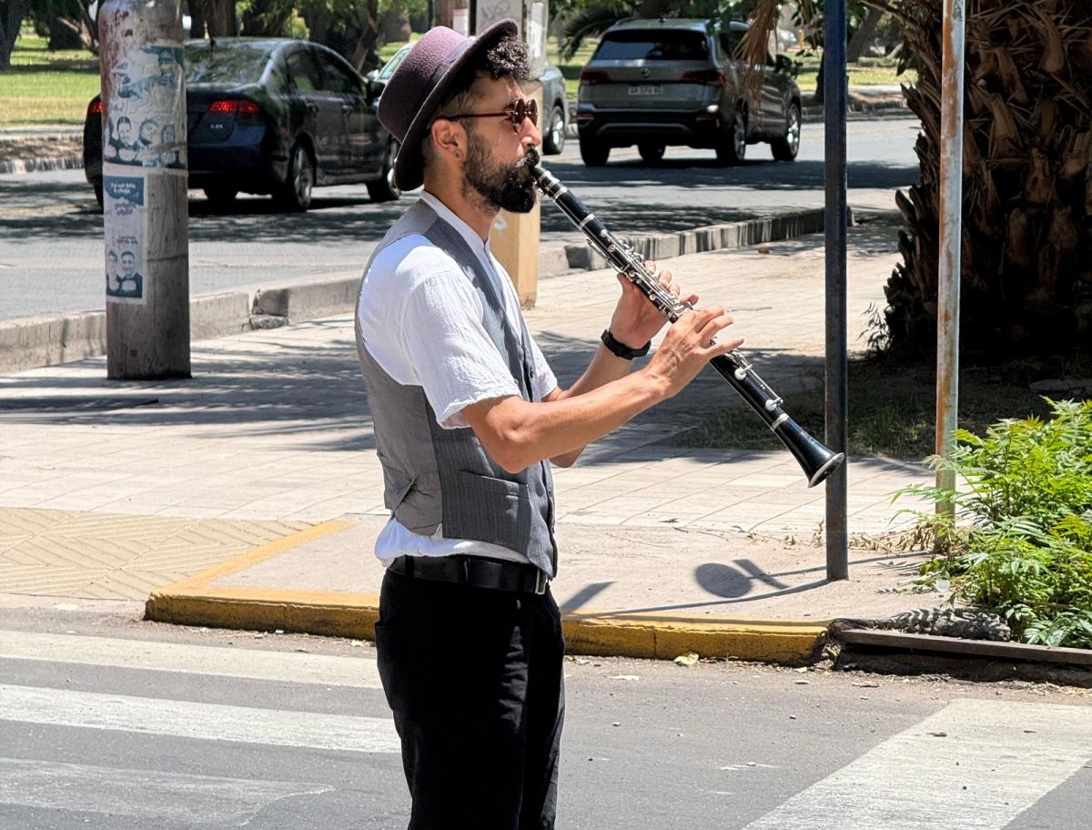 LA ESCENA. Imanol, acompañado por Jonathan en la batería, interpreta el himno nacional para transformar su propia ciudad. La música cargó de sentido la entrevista.