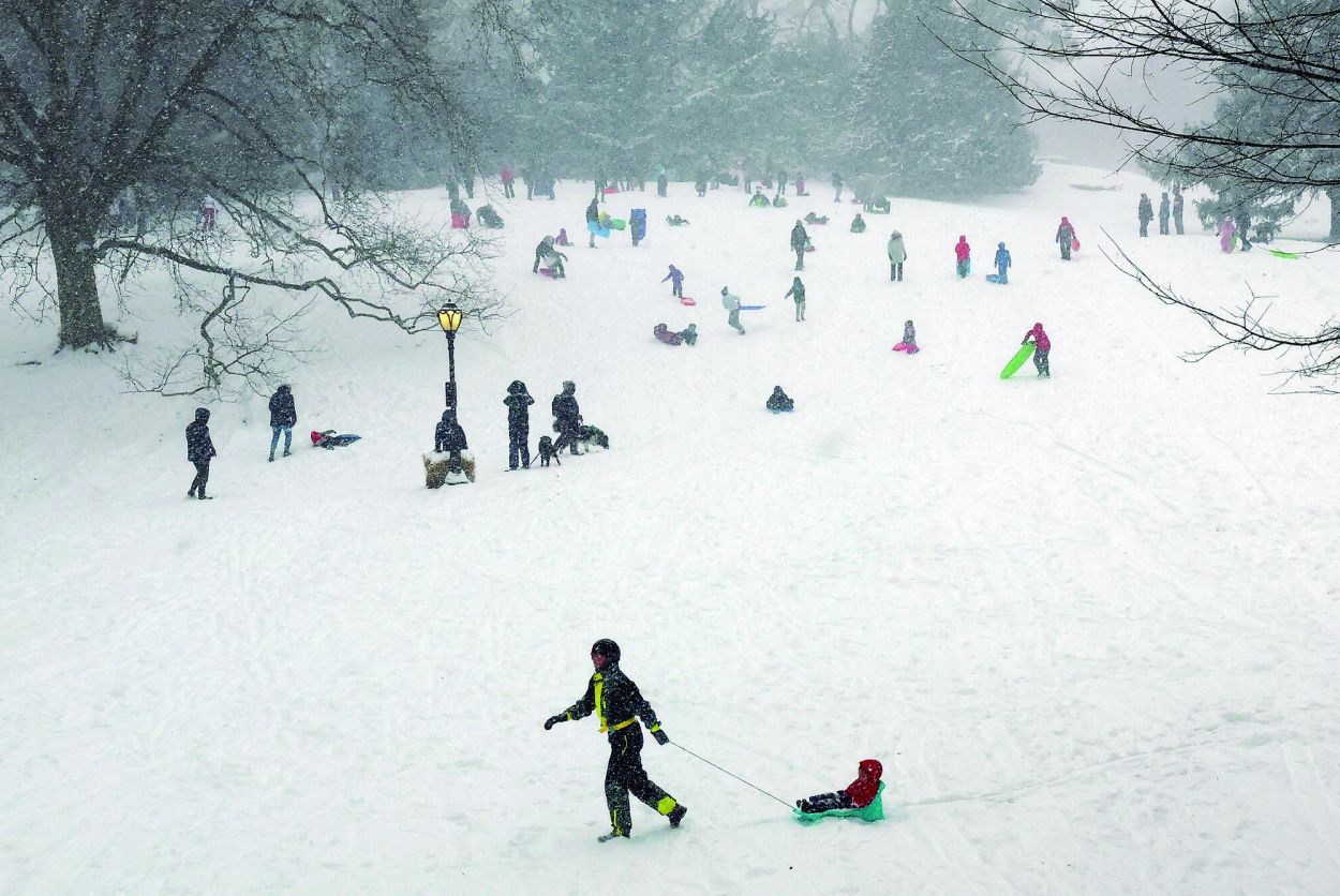 EN EL CENTRAL PARK. Residentes de Nueva York salieron a aprovechar la nieve para andar en trineos. afp