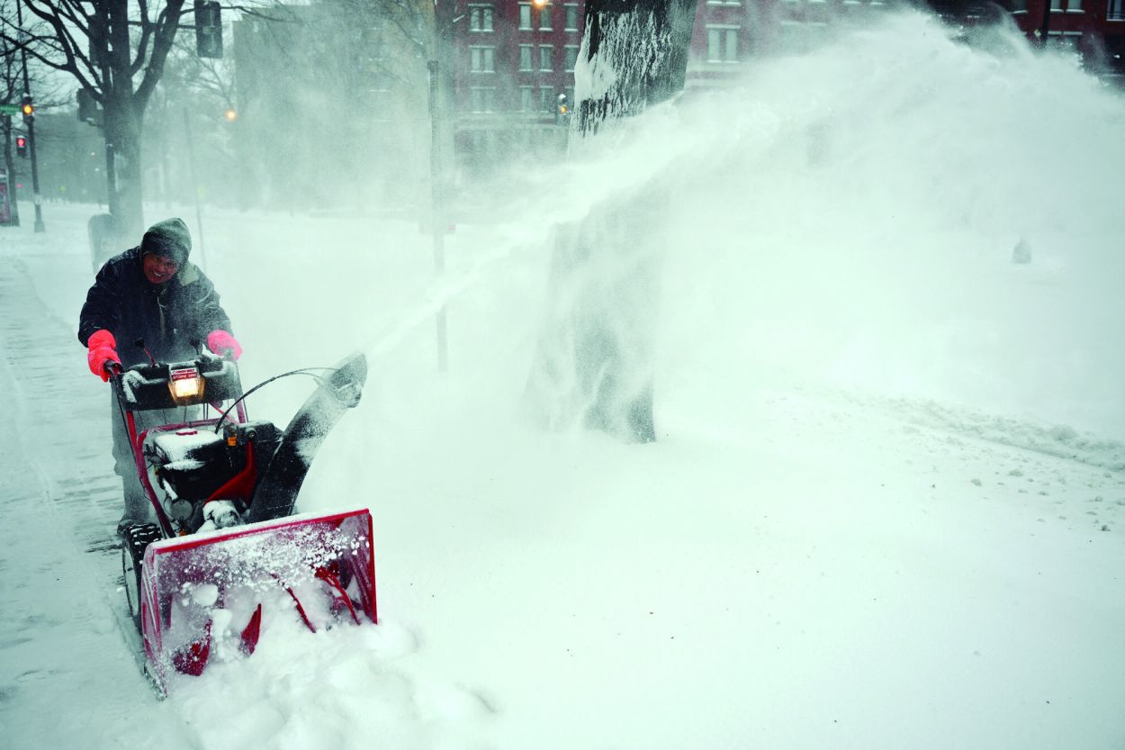 EN WASHINGTON. Un trabajador retira la nieve de la fachada de un edificio en la capital estadounidense.
