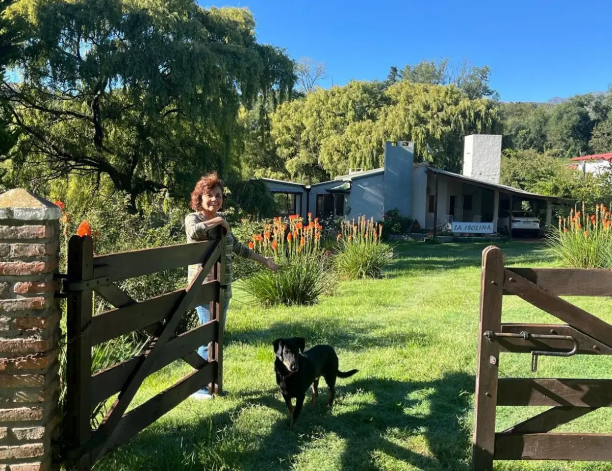 ¡ADELANTE! Mónica Valdez posa junto al portón de entrada de “La Isolina”, su casa de Tafí de Valle que ofrece en la plataforma Home Exchange.