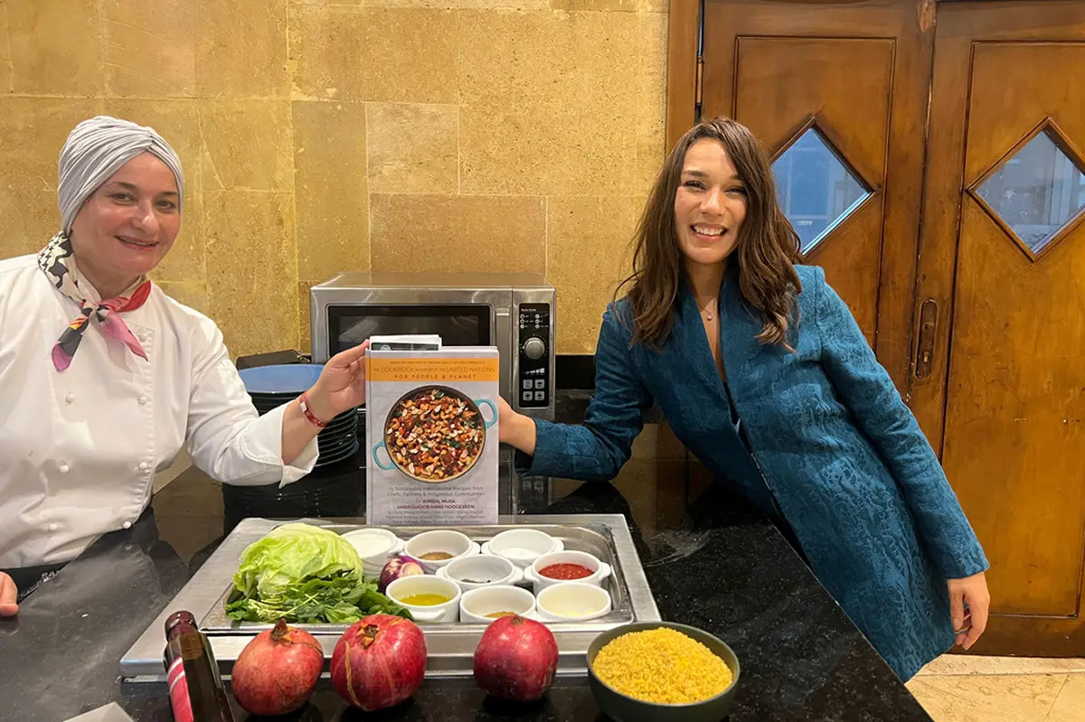 RECETARIO. La embajadora del Programa Mundial de Alimentos, la chef Manal Al Alem, y la fundadora de la ONG Kitchen Connection, Earlene Cruz, sostienen el libro de cocina en apoyo de las Naciones Unidas.