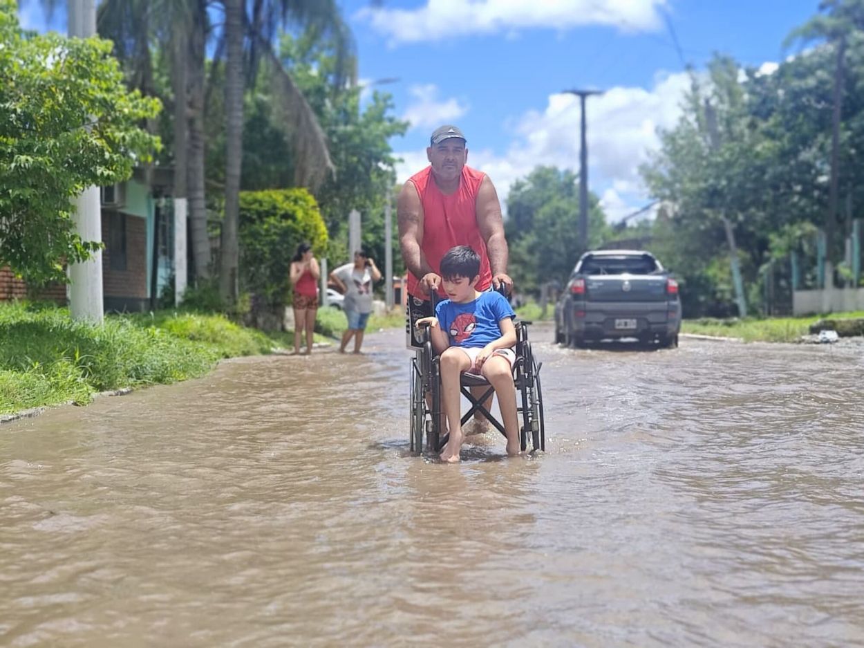 EN CONCEPCIÓN. Un hombre asiste a un niño en silla de ruedas.