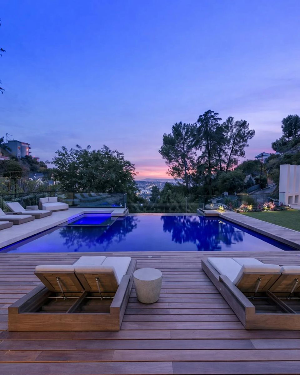 Un oasis difícil de encontrar en Los Ángeles: jardín amplio, palmeras y áreas de descanso rodean la casa.