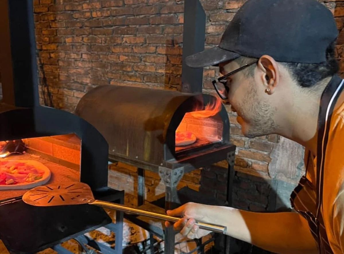 RPIZZARÍA. Lucas en el horno pizzero con el que comenzó el proyecto.