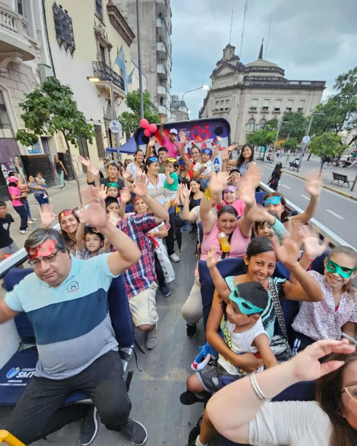 DIVERSIÓN. Niños y adultos bailan y saludan desde el autobús descapotable durante el paseo.