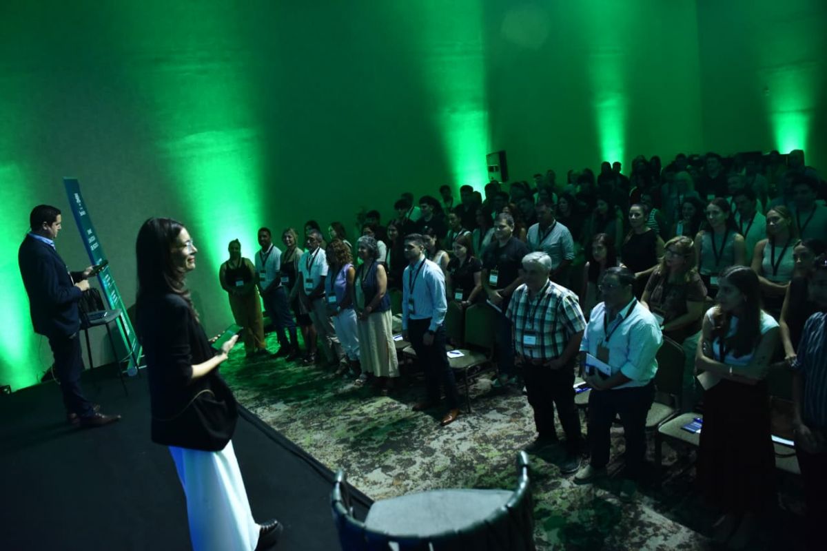 UN MINUTO SIN PANTALLAS. El público de pie, sin celulares ni relojes, durante el ejercicio del “minuto interno” propuesto para reflexionar sobre el tiempo y la atención. / LA GACETA, OSVALDO RIPOLL