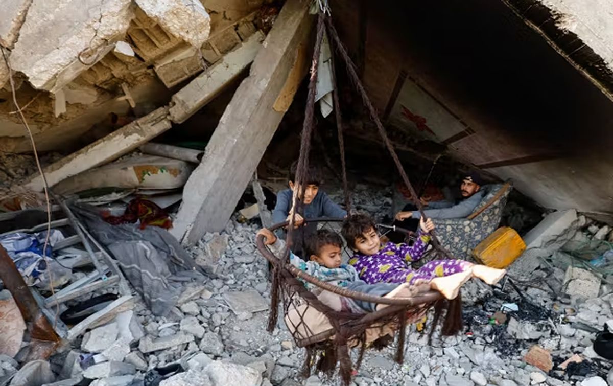 DESPLAZADOS POR LA GUERRA. Jóvenes y niños palestinos en refugios temporales levantados entre los restos de edificios destruidos. / REUTERS.